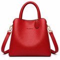 A bright red pebbled leather handbag with top handles and a detachable shoulder strap, shown on a clean white background. The brand name 'CLASSIC' is subtly embossed on the front.