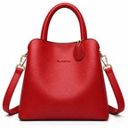 A bright red pebbled leather handbag with top handles and a detachable shoulder strap, shown on a clean white background. The brand name 'CLASSIC' is subtly embossed on the front.