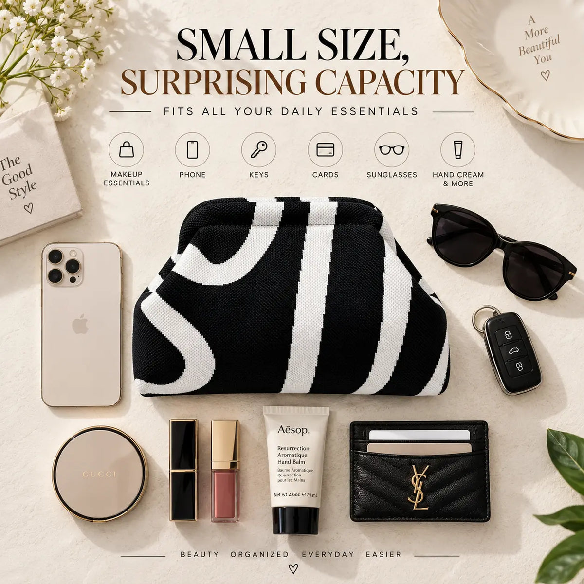 Black and white wave knit pouch surrounded by a phone, sunglasses, keys, cards, makeup and hand cream
