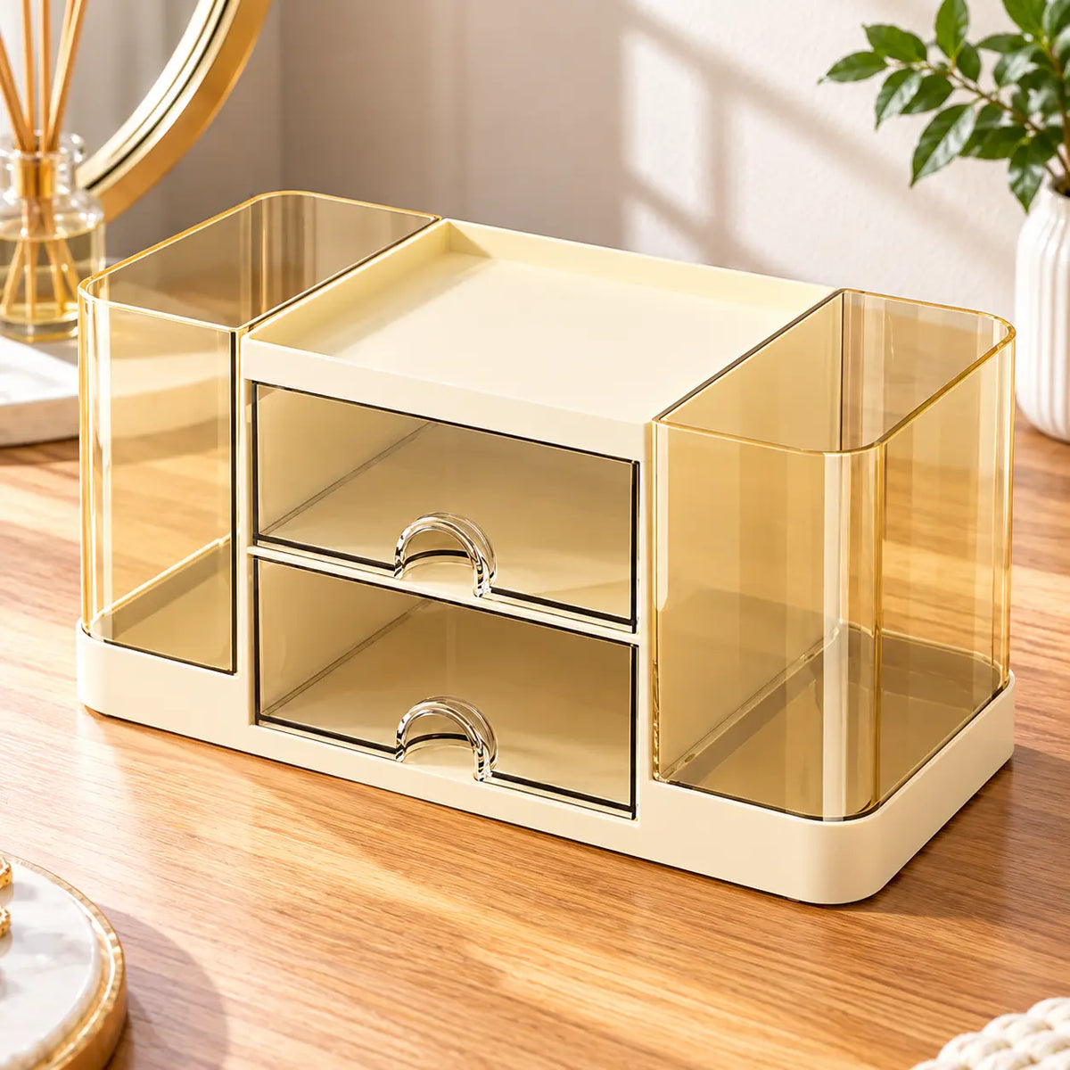Cream yellow makeup organizer with two transparent drawers, amber side compartments and an open top tray on a wooden vanity.