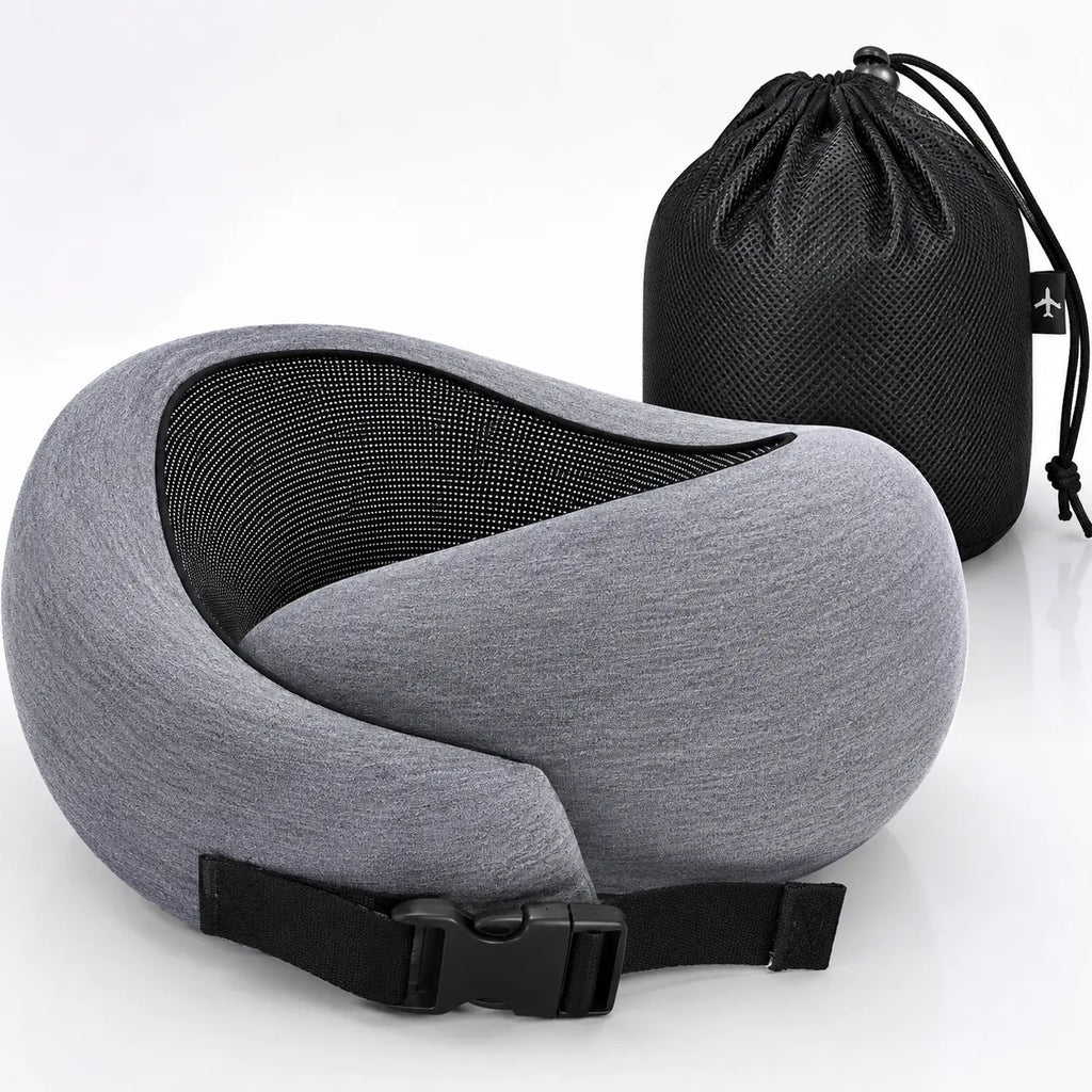 A gray and black travel neck pillow with an adjustable black strap, shown in front of a black drawstring storage bag on a white background.