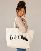 Off white Everything canvas tote bag carried on the shoulder by a woman in a neutral outfit