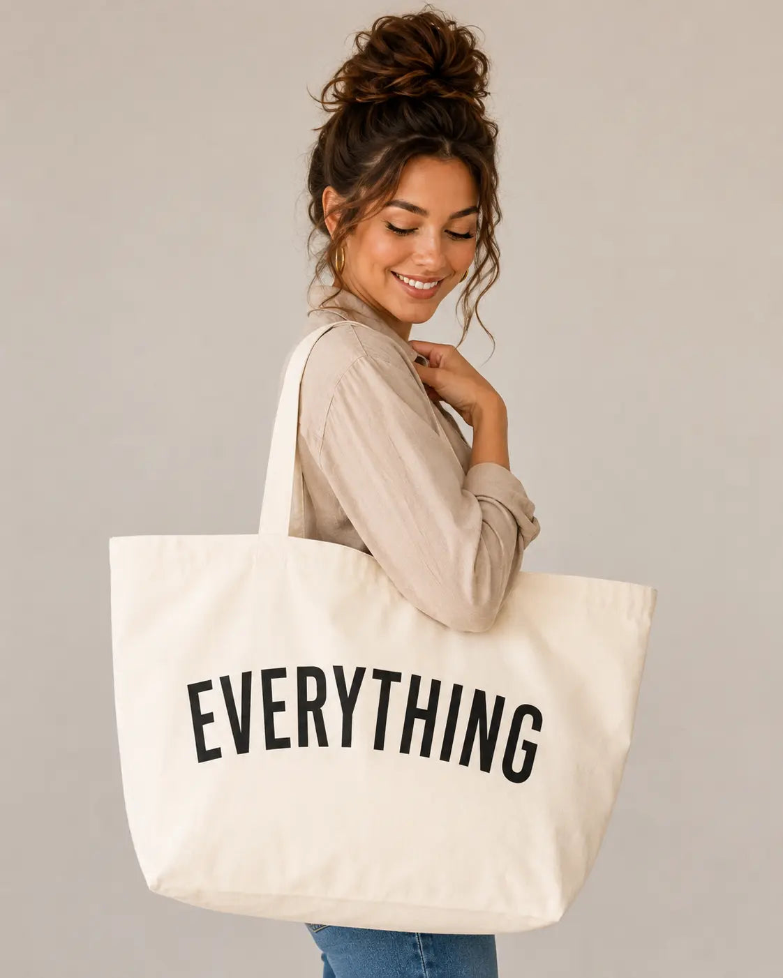 Off white Everything canvas tote bag carried on the shoulder by a woman in a neutral outfit