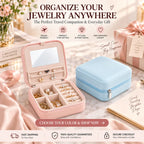 Blush pink and pastel blue travel jewelry organizers displayed on a marble table, with the pink case open and filled with jewelry